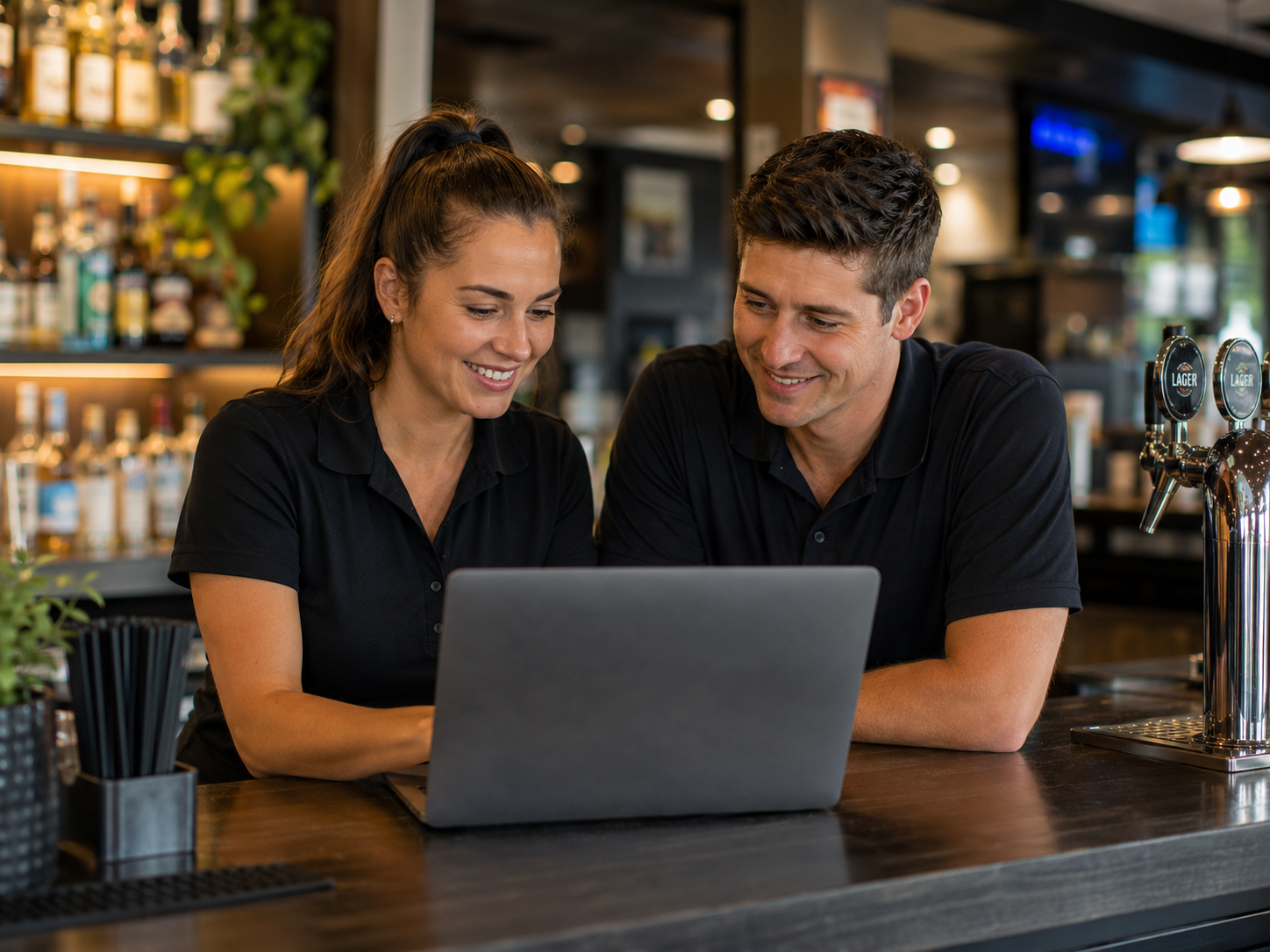 Club manager and staff member reviewing training together behind the bar
